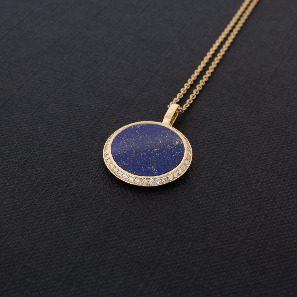 pendentif en or jaune sertie d'un disque de lapis lazuli et entouré de diamants